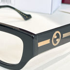 Close-up eyeglasses showing black frame and gold GG logo on temple