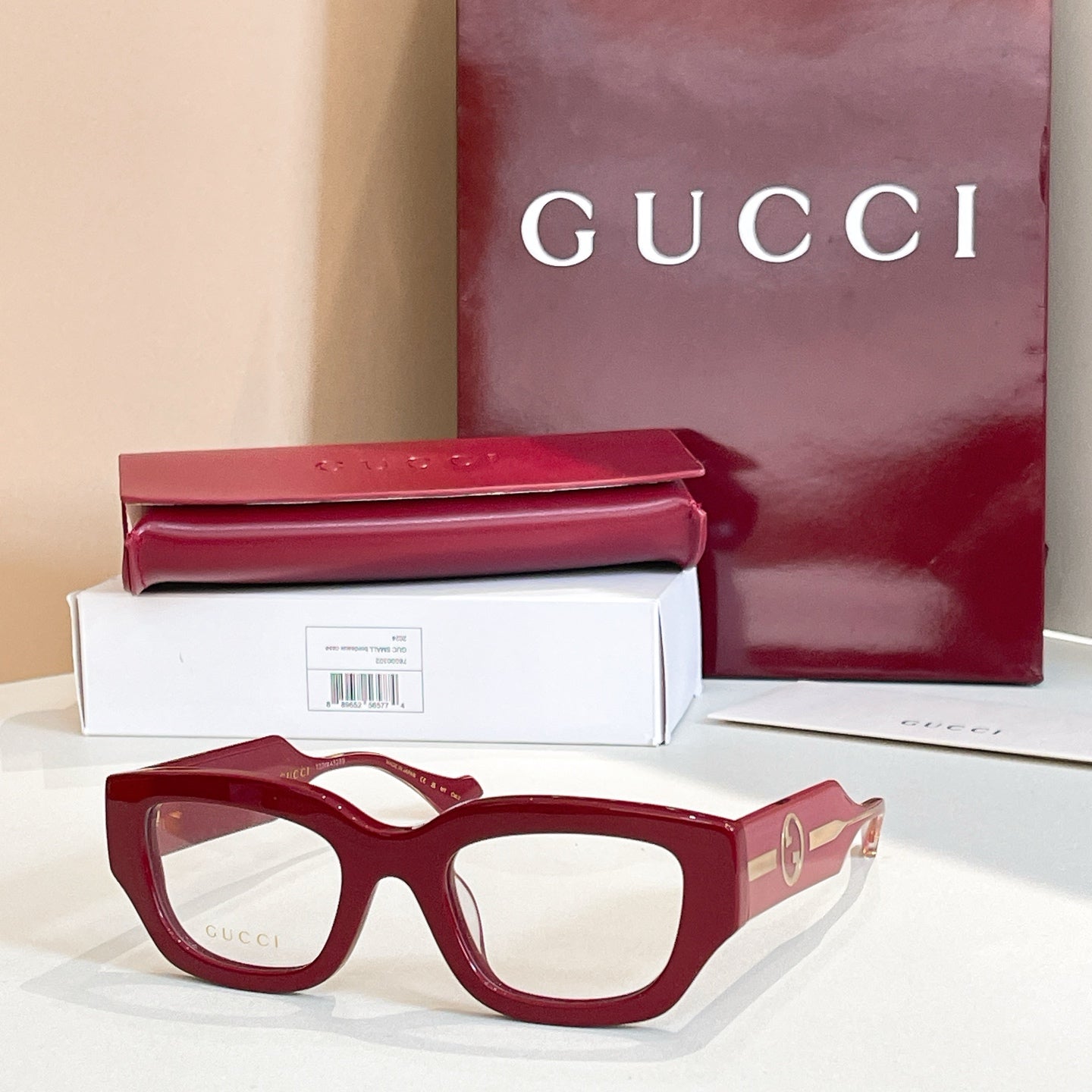 Eyeglasses with dark red frames and gold-tone side GG logo detail