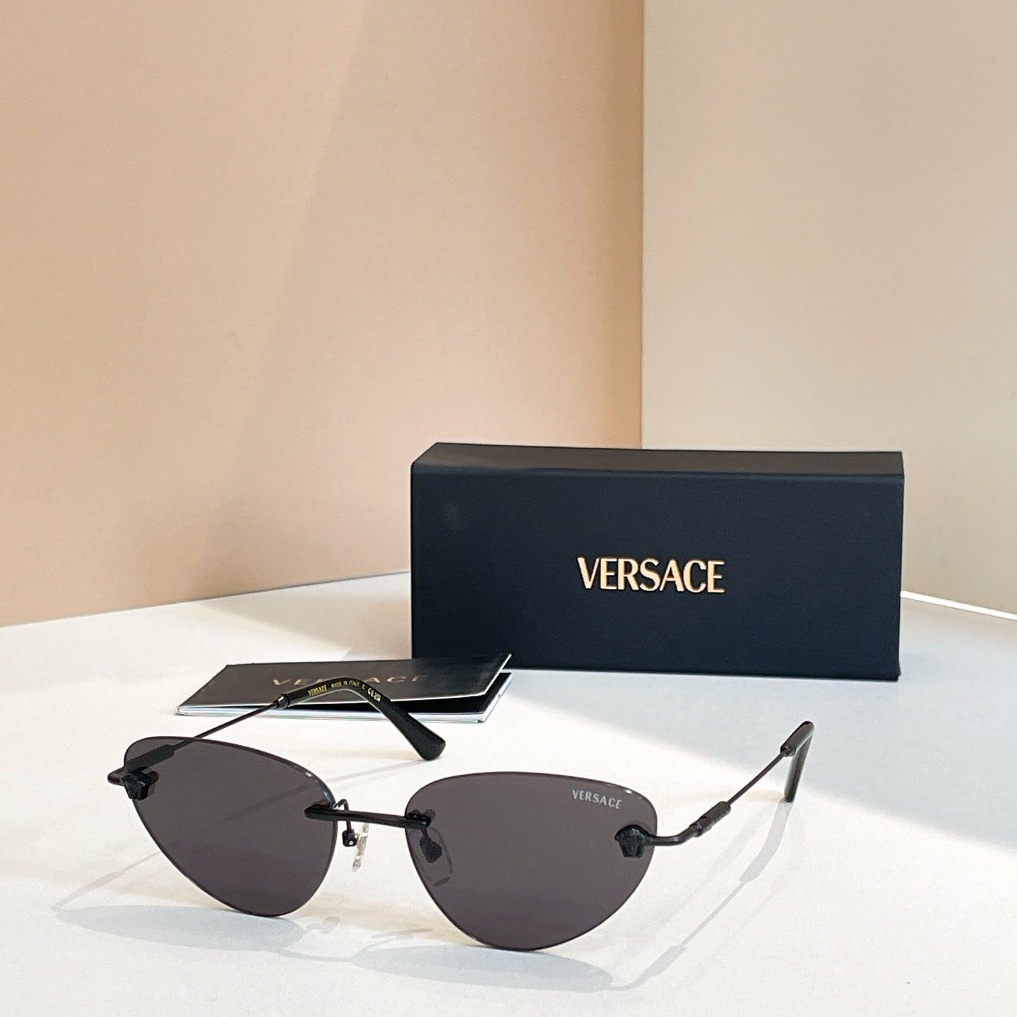 Versace sunglasses with dark tinted lenses and mixed black and gold frame, V logo