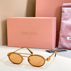Miu Miu round sunglasses with amber lenses and gold frame, front angle