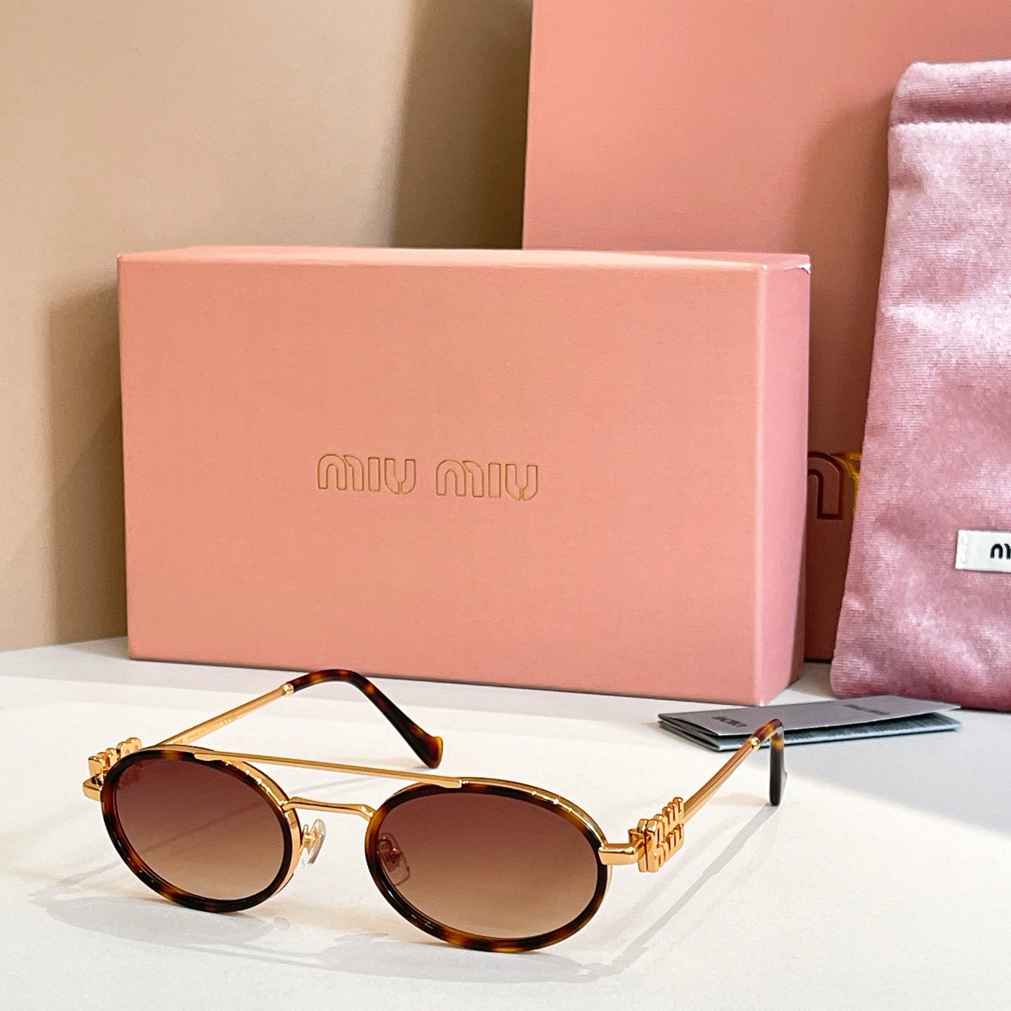 Miu Miu round sunglasses with gold frame and dark tinted lenses, side view