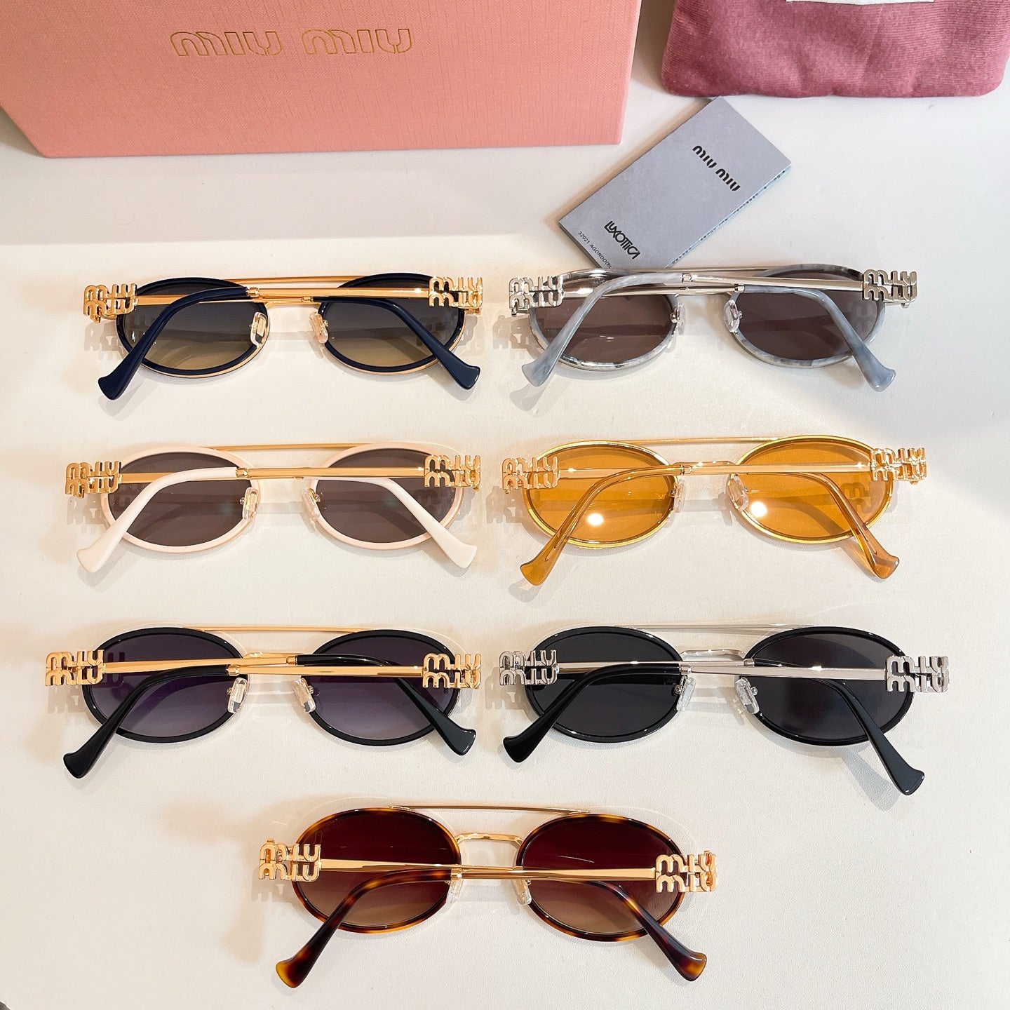 Miu Miu sunglasses assortment with gold, black, and amber frames, top view
