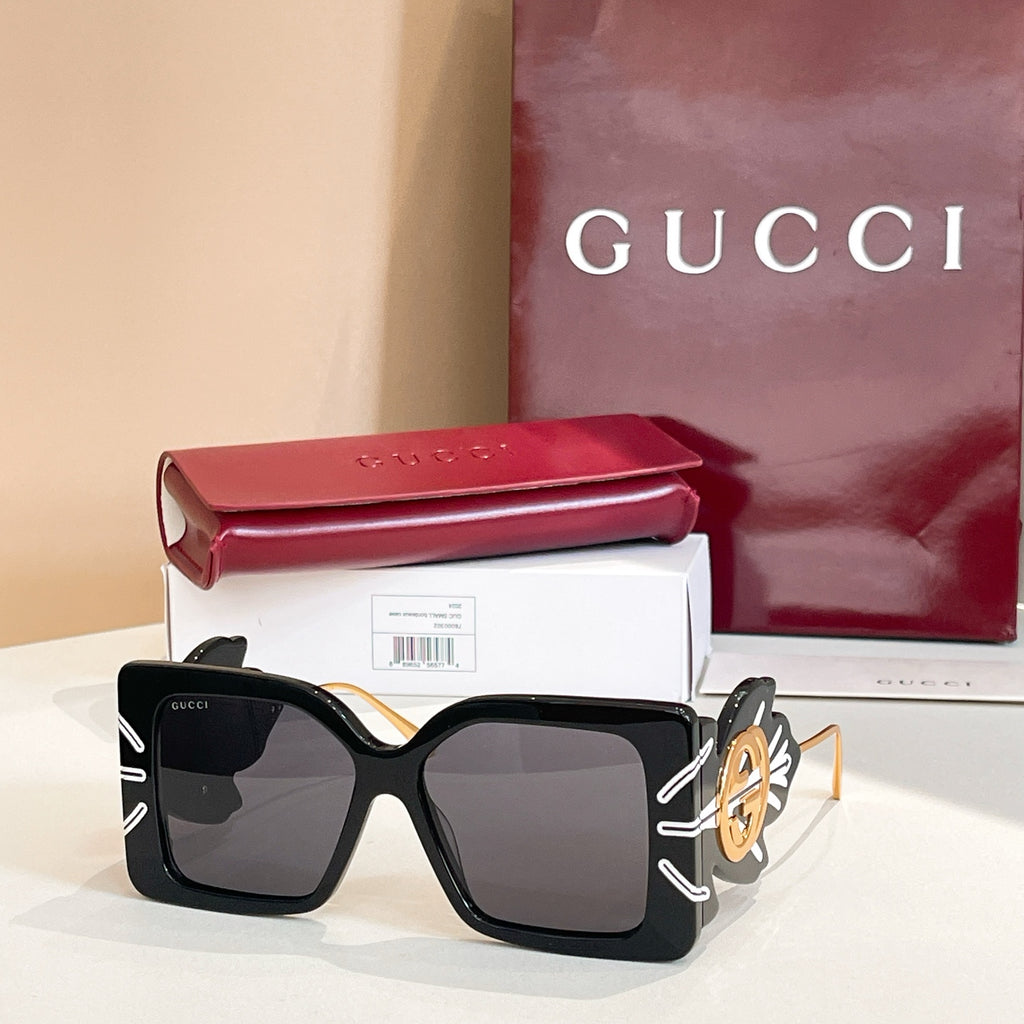 Square black sunglasses with dark lenses and gold logo on side arms