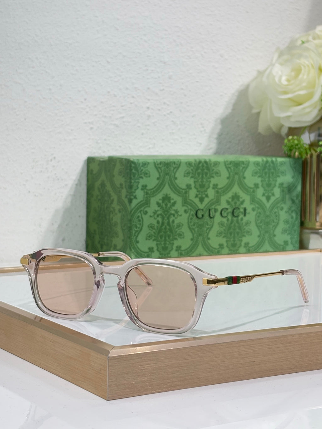 Transparent light-pink eyeglasses with tinted lenses and gold-toned arm details.