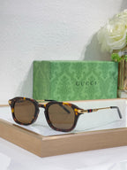 Tortoise-frame eyeglasses with dark tinted lenses and gold-toned arm details.