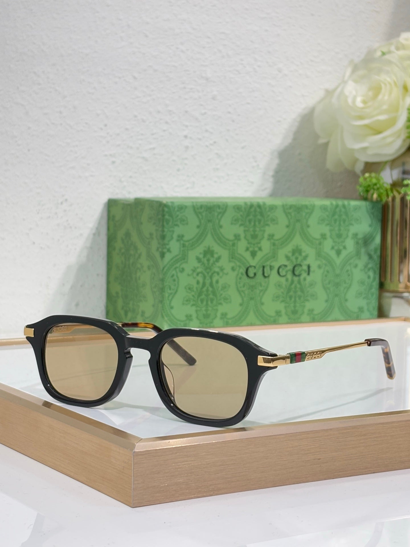 Black eyeglasses with clear lenses and gold-toned arm details.