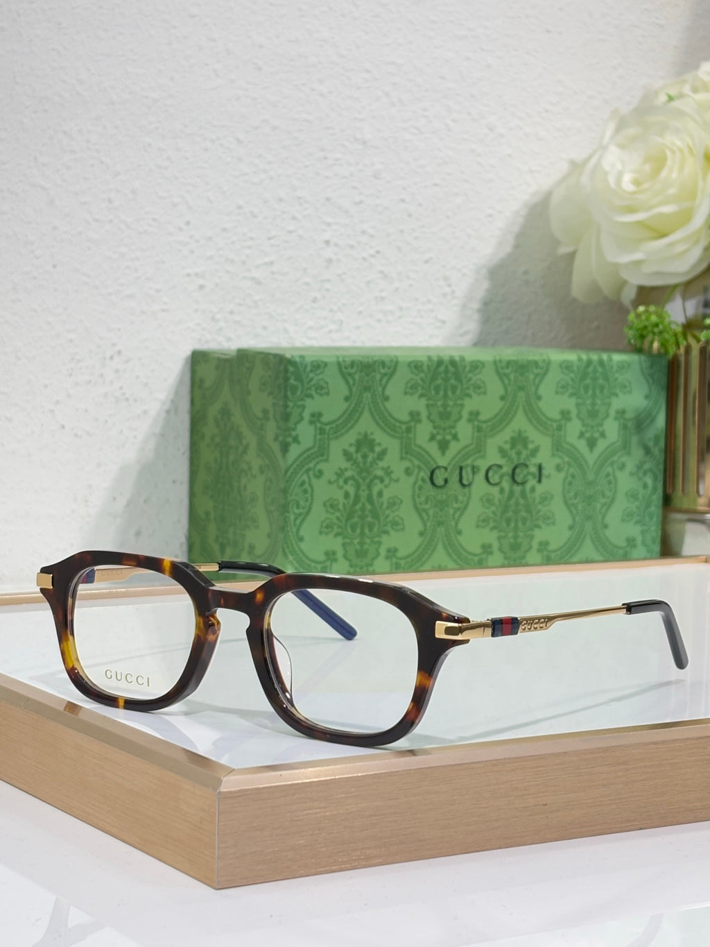 Dark tortoise eyeglasses with clear lenses and gold-toned arm details.