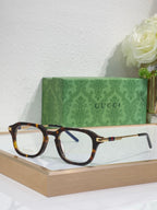 Dark tortoise eyeglasses with clear lenses and gold-toned arm details.