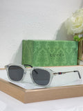 Silver-gray round eyeglasses with dark tinted lenses and gold-toned arm detail.