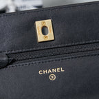 Chanel logo plate and zipper on black leather flap bag, gold-tone hardware