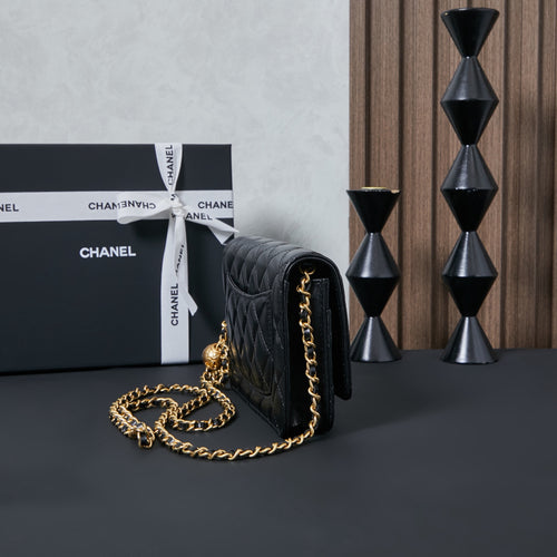 Chanel quilted leather shoulder bag in black, side view with gold chain strap