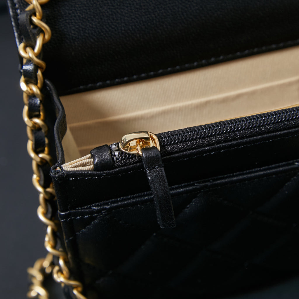 Chanel chain strap attachment on black leather bag with pocket flap detail