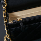 Chanel chain strap attachment on black leather bag with pocket flap detail