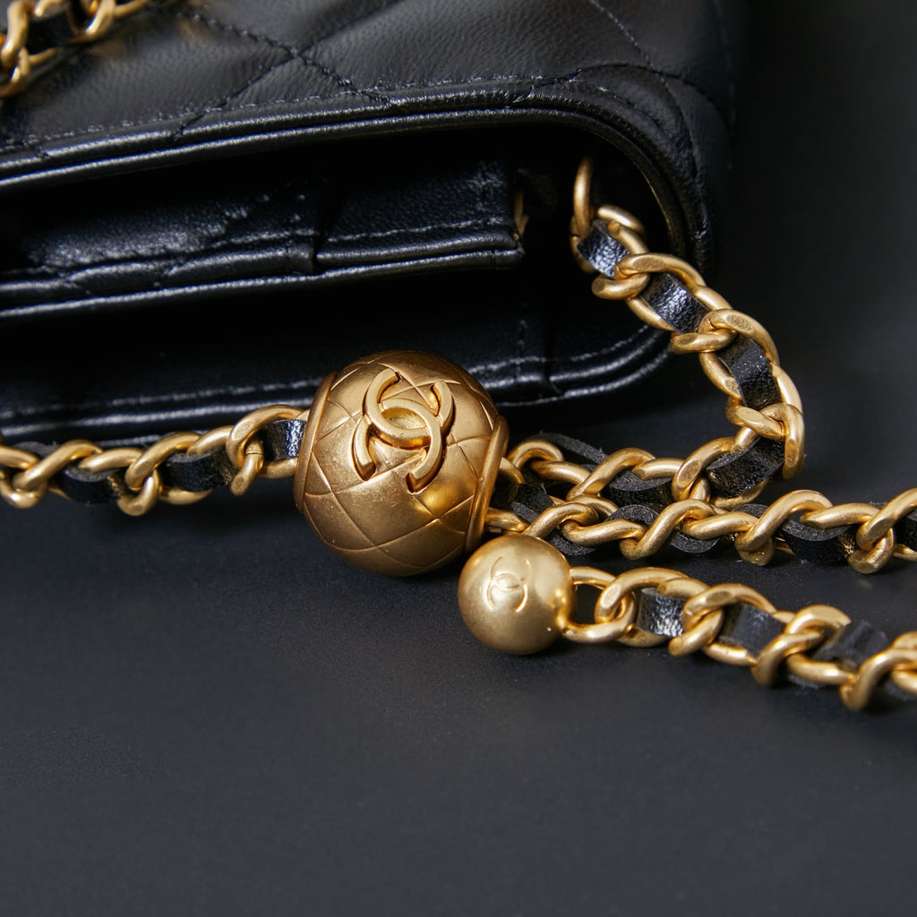Chanel chain strap with gold-toned hardware on black leather flap and clasp