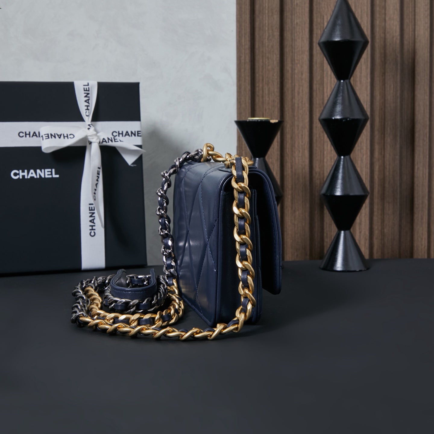 Chanel flap shoulder bag in navy blue with top handle and chain strap.