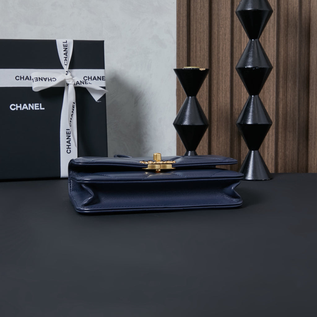 Chanel flap bag with gold clasp, navy blue, with smooth front panel.
