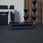 Chanel flap bag with gold clasp, navy blue, with smooth front panel.