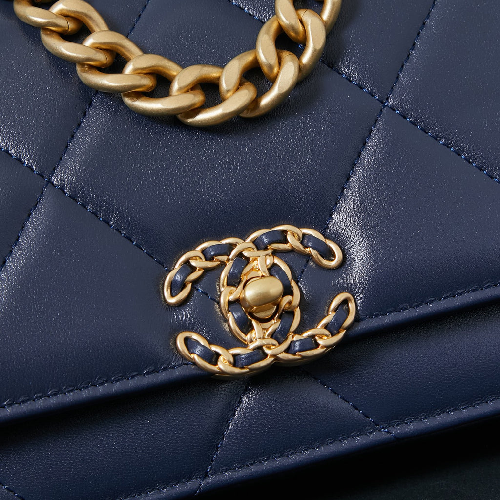 Chanel quilted navy blue bag with gold chain strap across the flap.