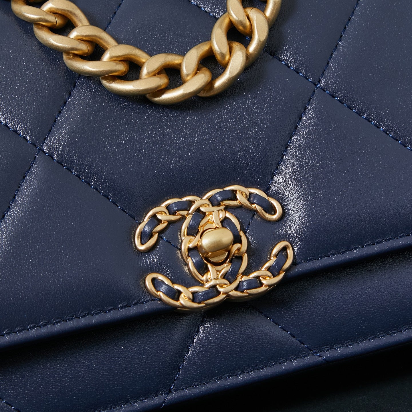 Chanel quilted navy blue bag with gold chain strap across the flap.
