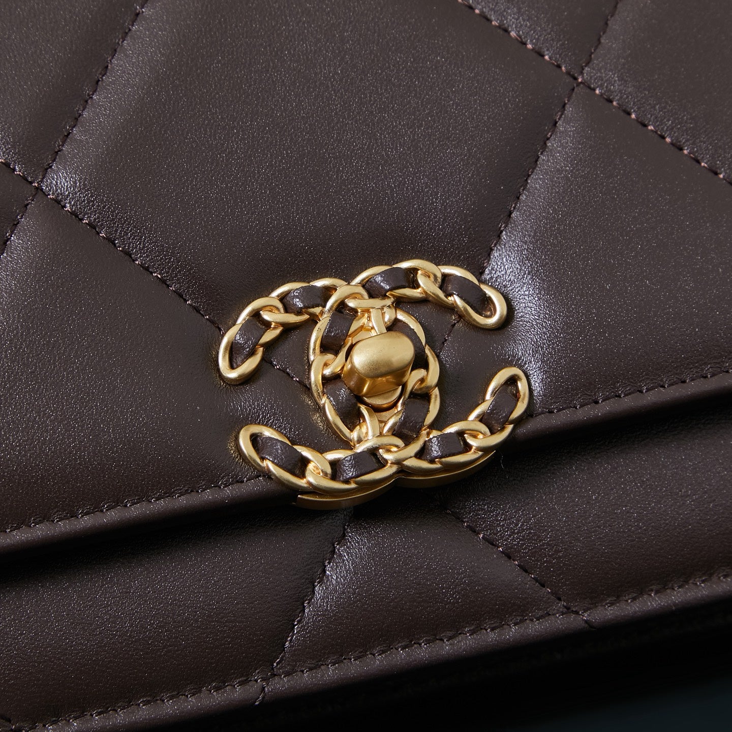 Chanel quilted bag close-up showing gold chain strap attachment