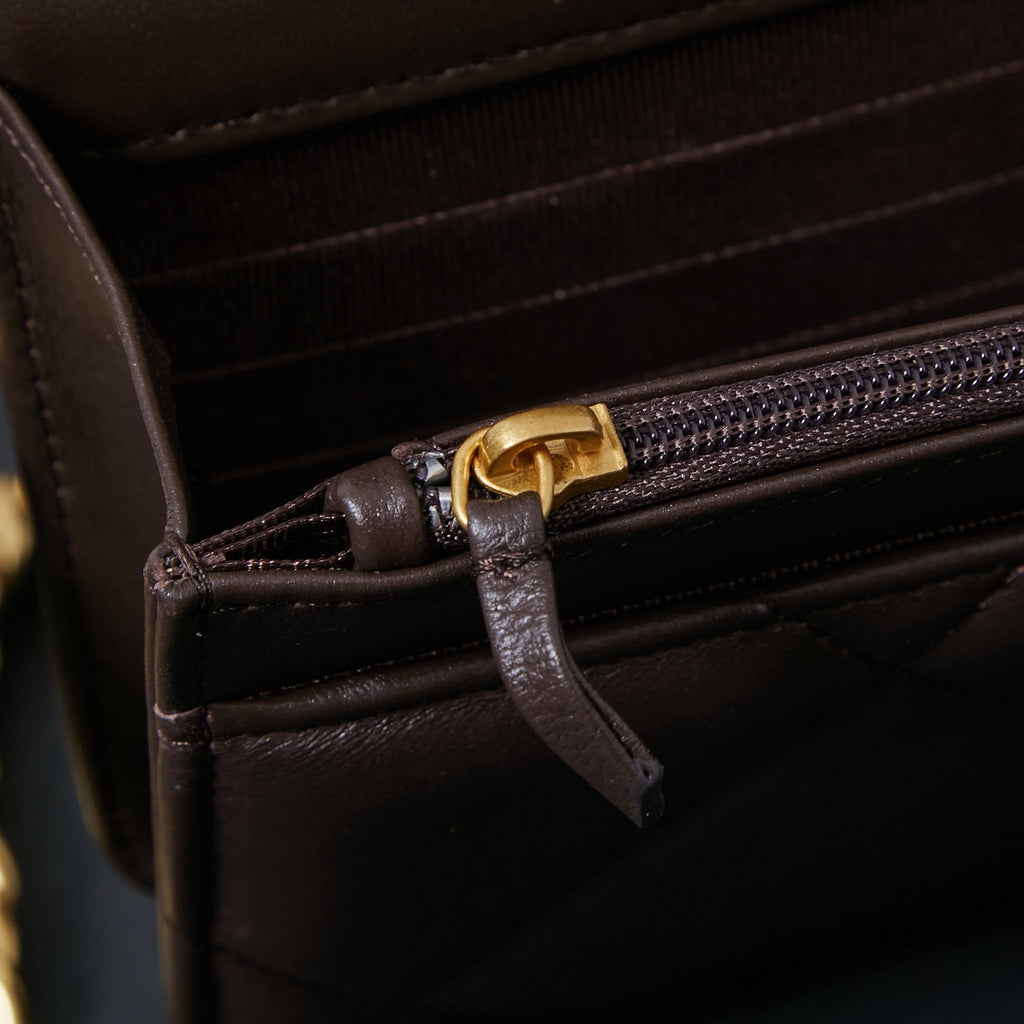 Chanel bag interior close-up with zip pocket and leather pull tab