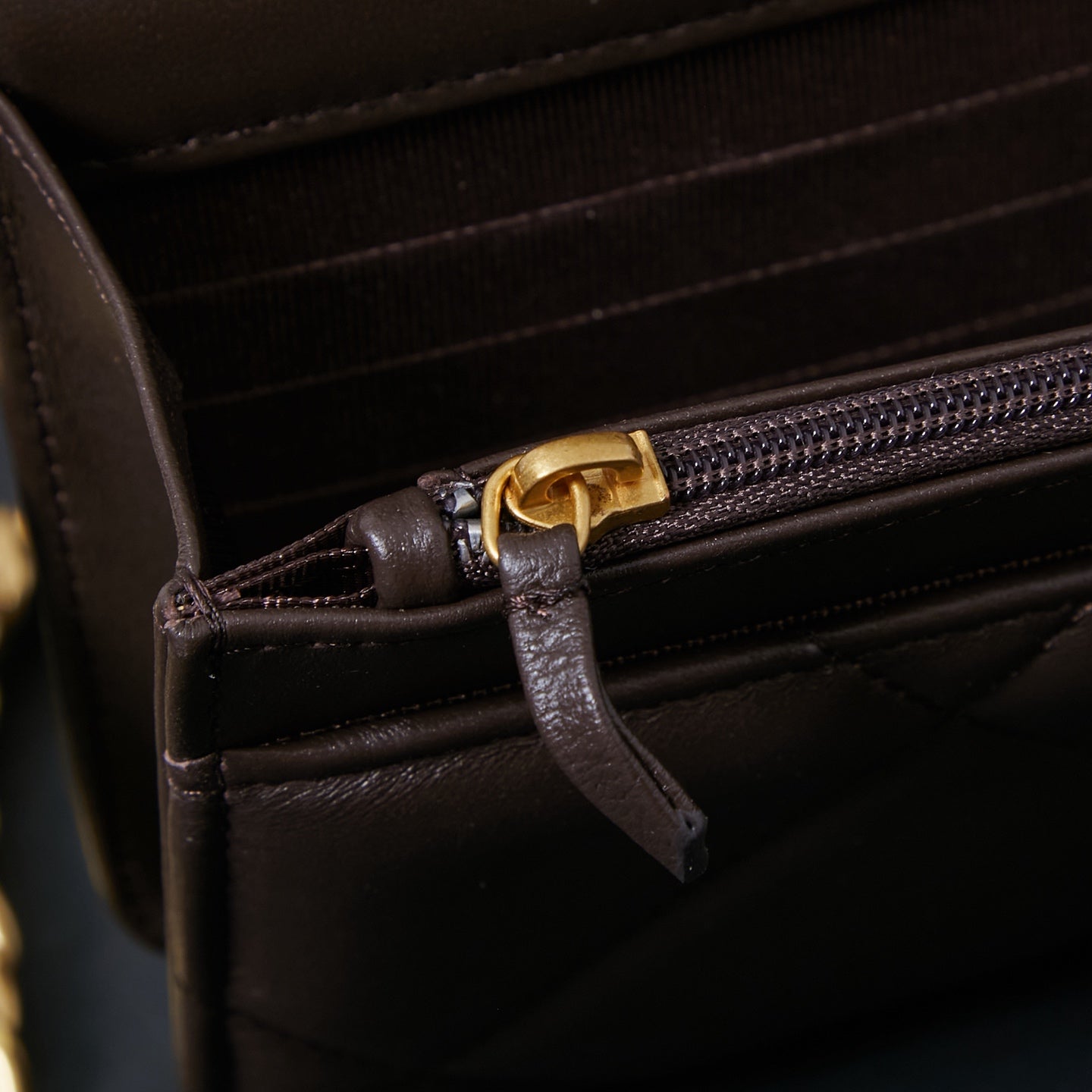Chanel bag interior close-up with zip pocket and leather pull tab