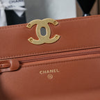 Chanel bag close-up of gold CC logo, tan-brown flap, and zipper trim