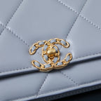 Light blue quilted flap bag with gold chain link detail on the front