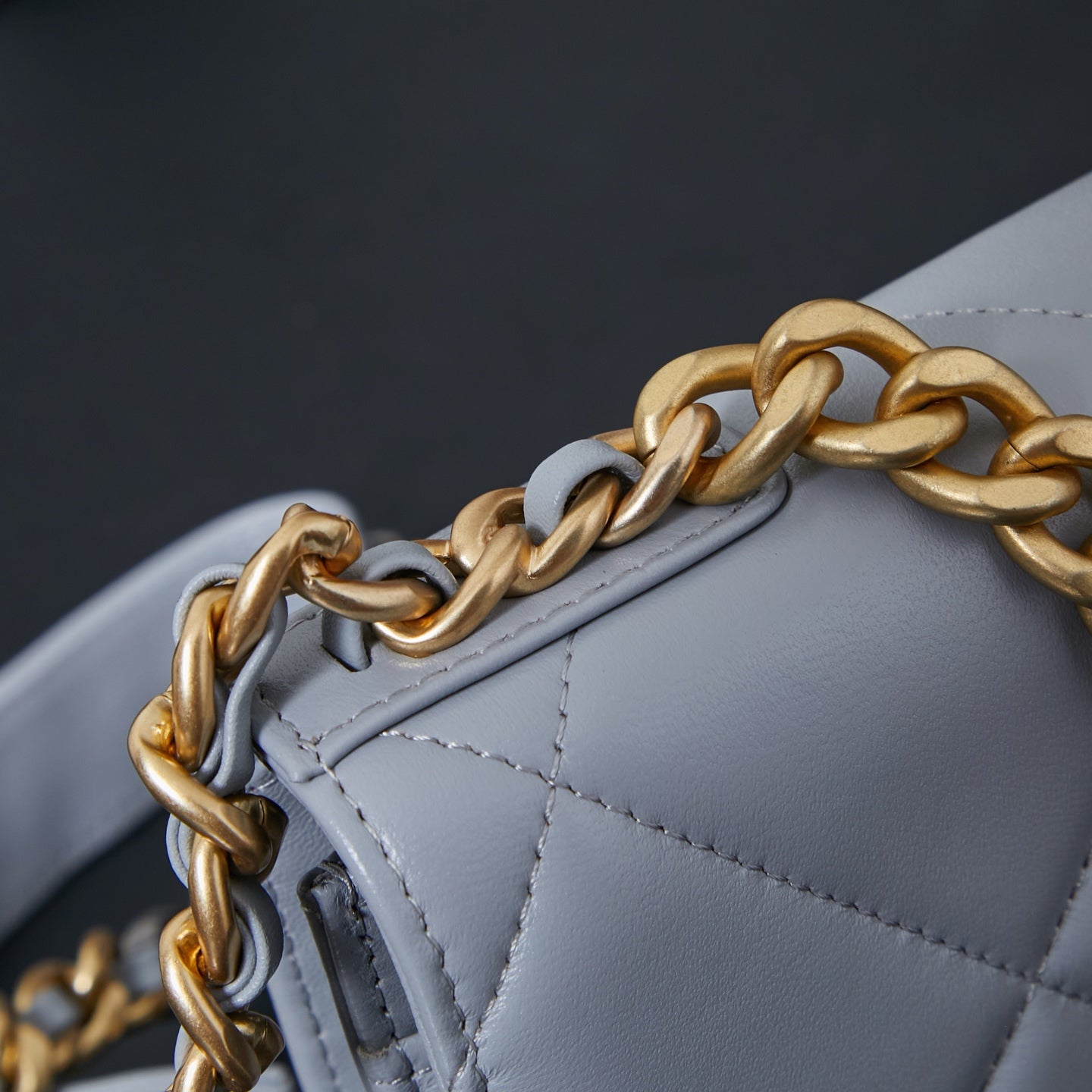 Light blue quilted shoulder bag with gold-and-silver chain strap close-up