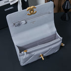 Light blue flap shoulder bag open view with inner pockets and turn-lock clasp