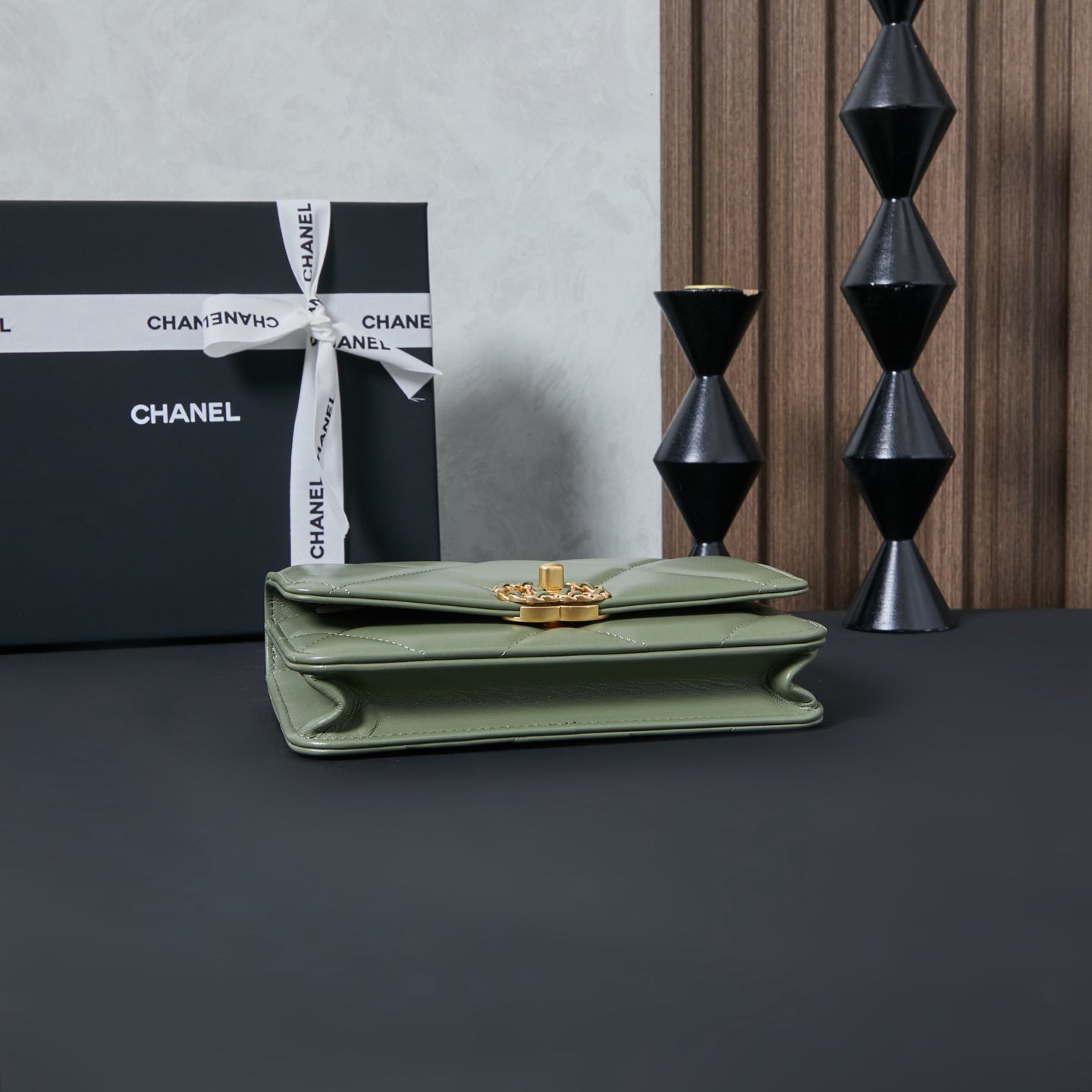 Olive green Chanel flap bag with gold-tone emblem on top clasp