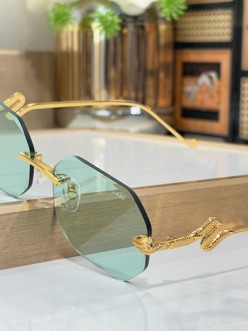 Bvlgari sunglasses side view with teal gradient lenses and gold-tone metal frames
