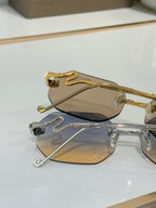 Bvlgari sunglasses close-up: gold-tone frame, beige lenses, rhinestone emblem