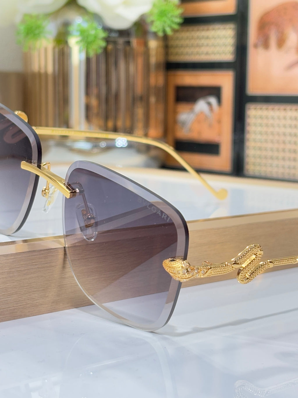 Bvlgari round sunglasses with gold frame and dark gray gradient lenses, close-up
