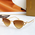 Gold cat-eye glasses with dark amber lenses and multicolor jeweled frame accents