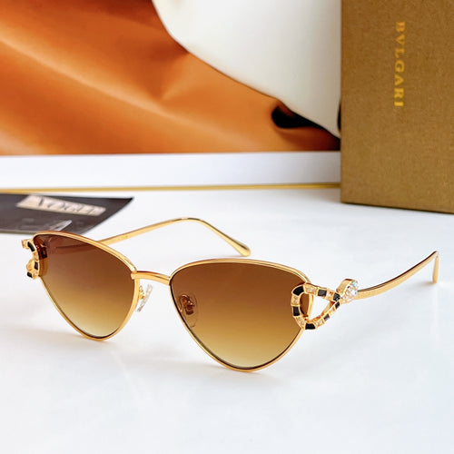 Gold cat-eye glasses with dark amber lenses and multicolor jeweled frame accents