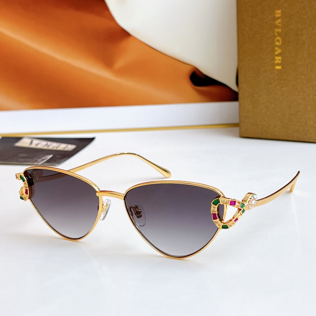 Gold cat-eye glasses with dark gray-lavender lenses and multicolor jeweled bridge
