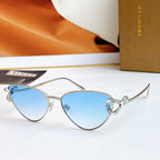 Silver cat-eye glasses with light blue lenses and multicolor jeweled bridge