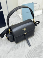 Black leather shoulder bag with gold-tone logo plaque, flap closure, and crossbody strap
