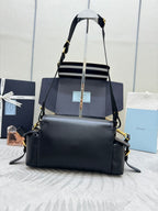 Structured black Prada shoulder bag with gold-tone hardware and adjustable crossbody strap