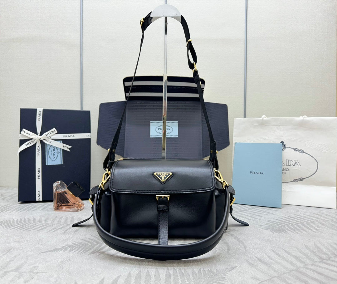 Structured black shoulder bag with gold-tone hardware, top handles, and crossbody strap