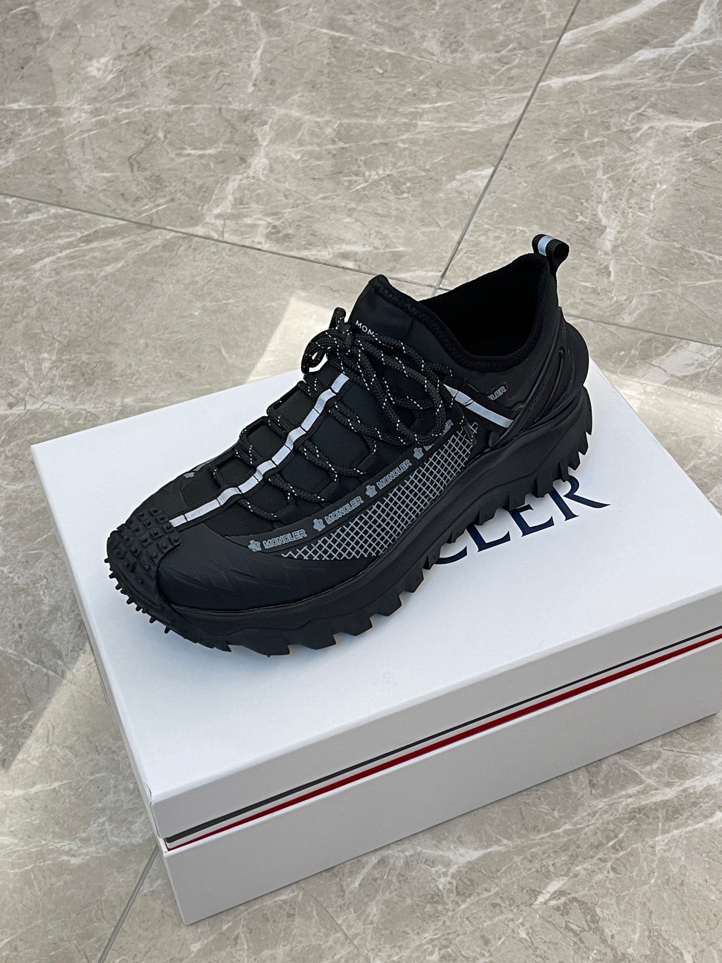 Black Moncler lace-up sneakers with grippy outsole and chunky design
