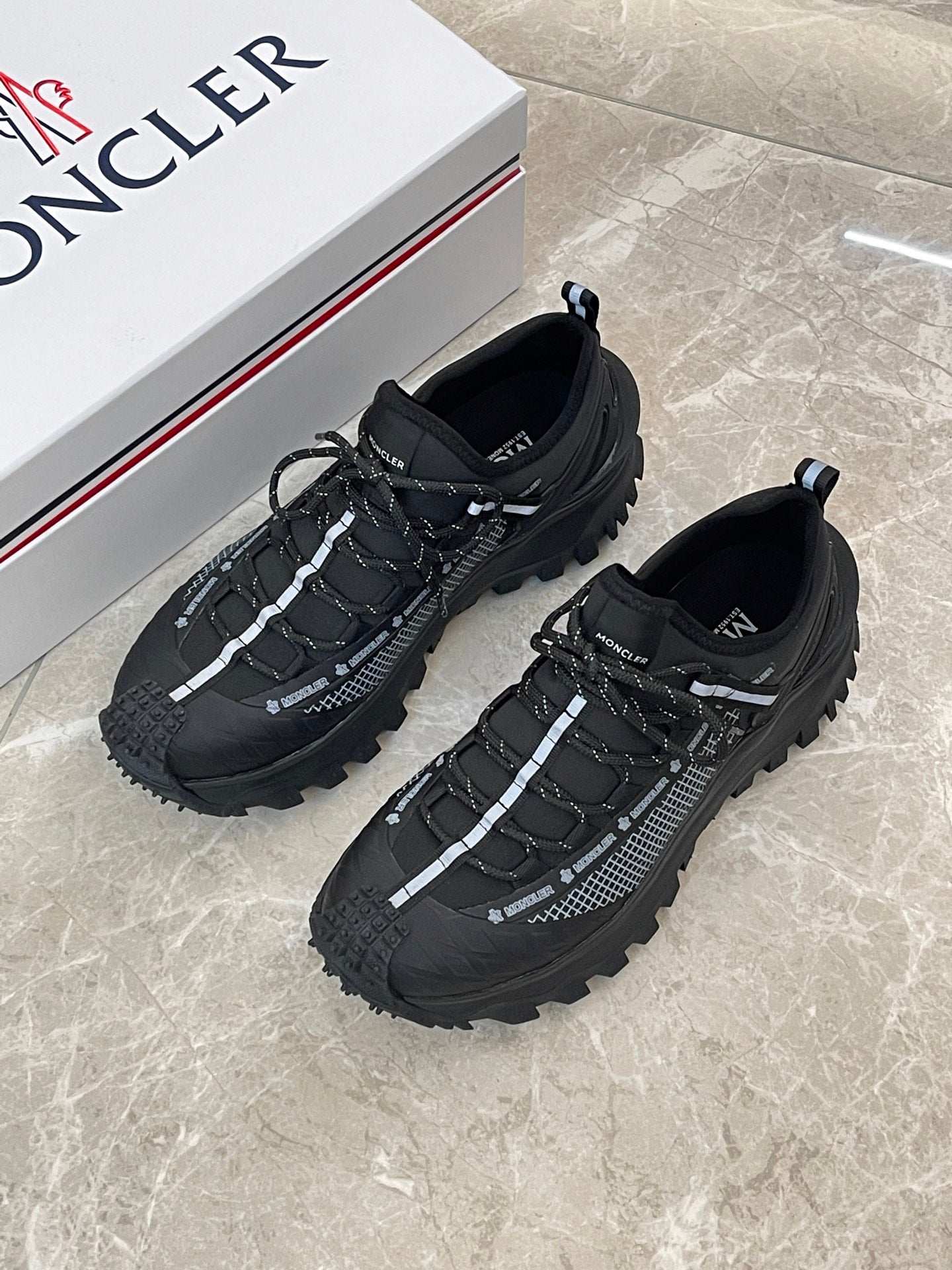 Black Moncler trail sneakers with lace-up and textured side panels