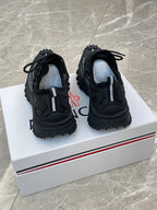 Black Moncler sneakers with side stitching and exposed tread, heel view