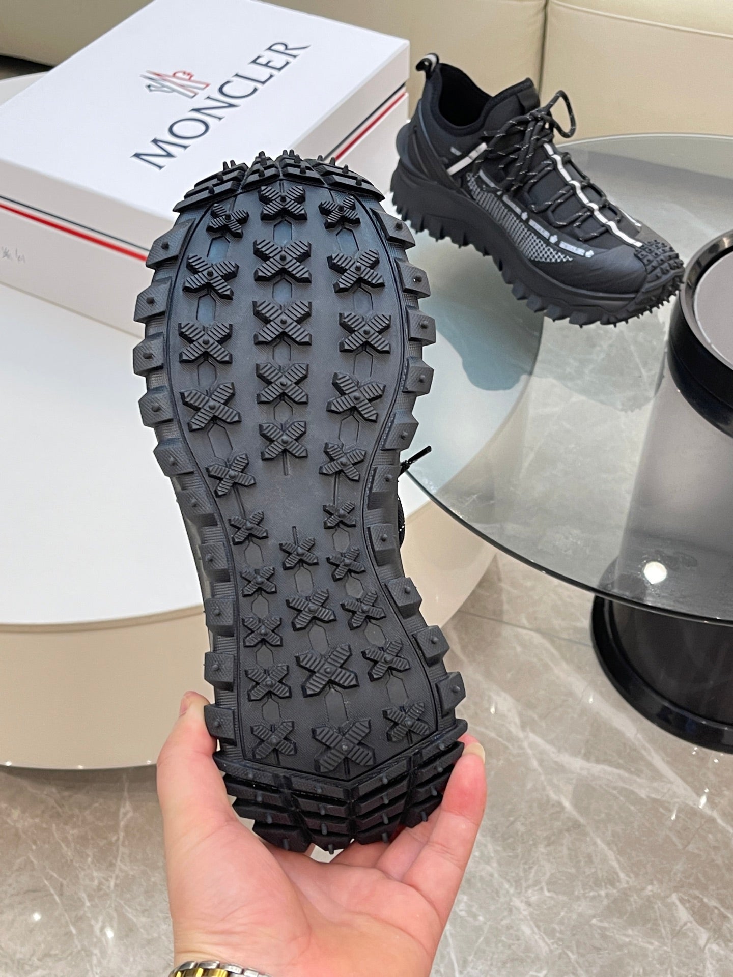 Black Moncler sneaker outsole with molded grip pattern, tread view