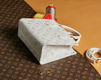 White monogram tote bag with top handles and gold-tone hardware