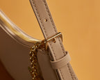 Louis Vuitton bag strap attachment with gold-tone clasp and stitched beige leather