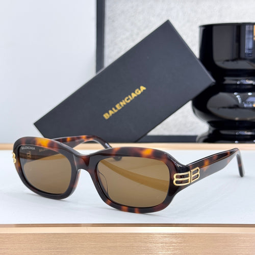 Balenciaga sunglasses with tortoise frame, amber-tinted lenses, and gold temple logo