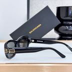 Balenciaga sunglasses in black with dark lenses, angled side view, gold temple logo