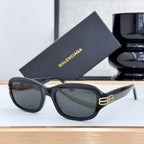 Balenciaga sunglasses with black frame, dark lenses, and gold logo at temple